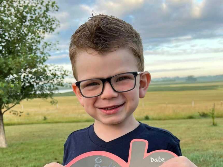 boy with Sanfilippo Syndrome standing in front of an open field